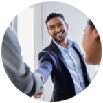 Businessman facing camera while shaking hand of person off camera after attending managers training.