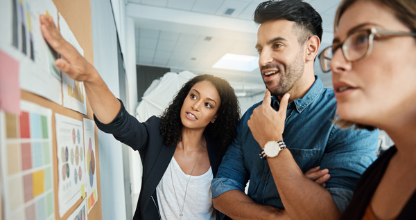 Executives looking at a wall of documents during a Strategic Planning for Executive Teams session.