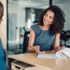 A business woman talking to a man in an office.