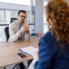 A businessman talking to a woman in an office.
