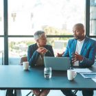 Two business people sitting at a conference table.